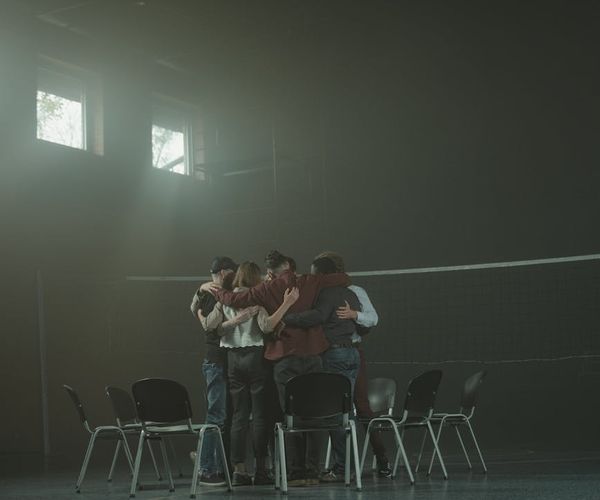 Group of men discussing and supporting each other during a workshop.